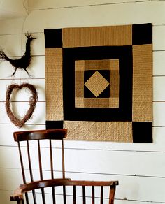 a wooden chair sitting in front of a wall hanging