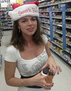 a woman wearing a santa hat and holding a bottle