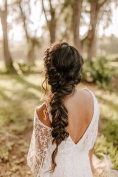 the back of a woman's head, wearing a white dress and braided hair