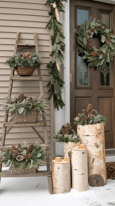 christmas wreaths and pine cones are on display in front of a house with a ladder