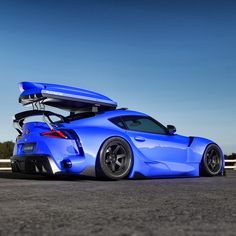 a blue sports car with its surfboard on top