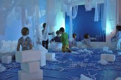 children are playing with blocks and chains on the floor in front of an ice room