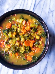 a bowl of soup with carrots and other vegetables