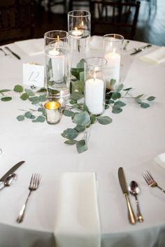 the table is set with silverware and candles