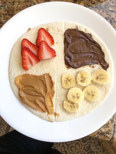 a white plate topped with chocolate, bananas and peanut butter on top of tortilla