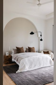 a large bed sitting in the middle of a bedroom next to a wall mounted ceiling fan