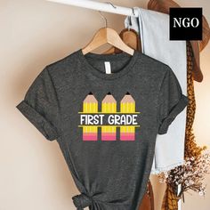 a t - shirt with the words first grade on it