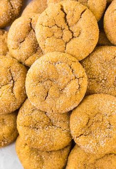 a pile of cookies sitting on top of a white plate covered in powdered sugar