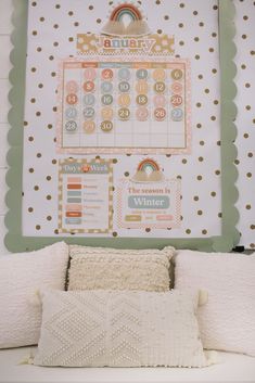 a white couch with pillows and a calendar on the wall