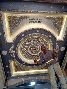 a man standing in front of a decorative ceiling