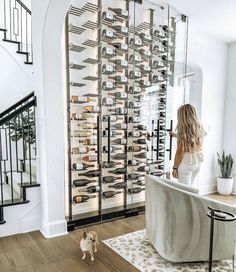 a woman standing in front of a wine rack