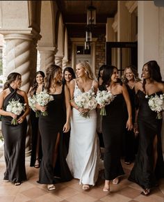 a group of women standing next to each other holding bouquets in their hands and smiling at the camera