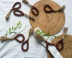 some beads are laying on a table next to a straw hat and two napkins