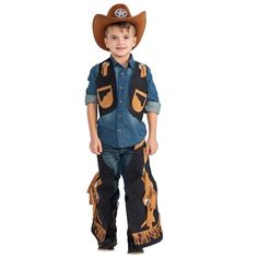 a young boy wearing a cowboy hat and overalls with his hands in his pockets