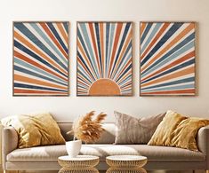 two sunburst paintings on the wall above a couch