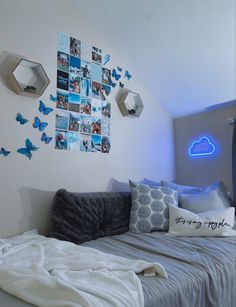 a bed sitting in a bedroom next to a wall with pictures on it and blue lights