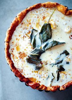 an overhead view of a pie with cheese and leaves