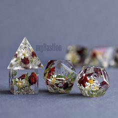 three glass vases with flowers in them sitting on a table next to each other