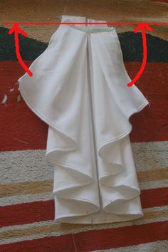 a piece of white cloth with red arrows pointing to the top and bottom of it