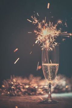 a champagne glass with sparklers in the background