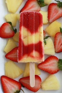 a popsicle with strawberries and pineapples on it sitting on a plate