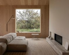 a living room filled with furniture and a fire place in front of a large window