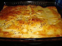 a casserole in a glass baking dish on top of a stove with black pepper sprinkles