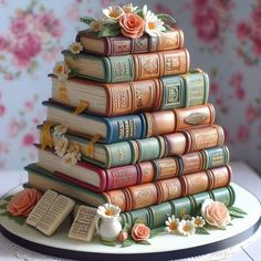 there is a cake made out of books and flowers on the top of each book