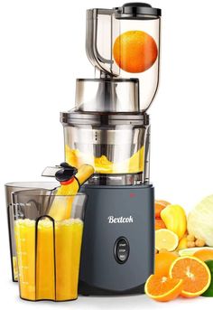 a blender filled with oranges and juice next to other fruit and vegetables on a white background