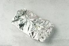 a piece of tin foil sitting on top of a white counter covered in silver foil