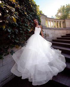 a woman in a wedding dress standing on some steps