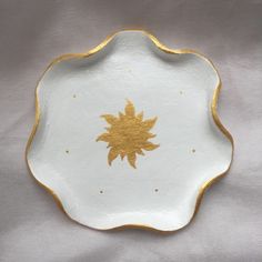 a white and gold plate with an ornate design