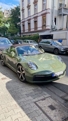 a green sports car is parked on the street