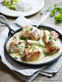 chicken and white sauce in a skillet on a wooden table