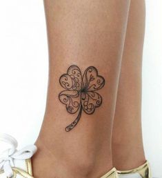 a close up of a person's foot with a clover tattoo on the ankle