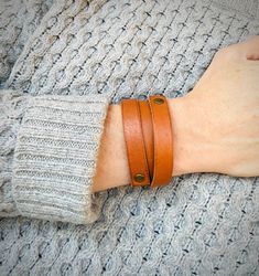 a person wearing a brown leather bracelet