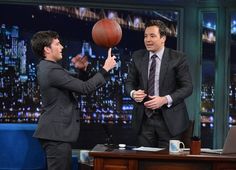 two men in suits are playing with a basketball on the set of late night show