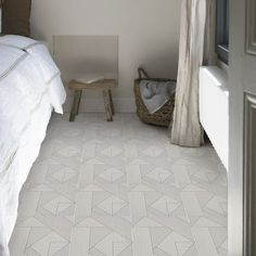 a white bed sitting next to a window in a bedroom