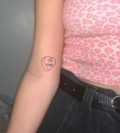 a woman with a heart tattoo on her arm