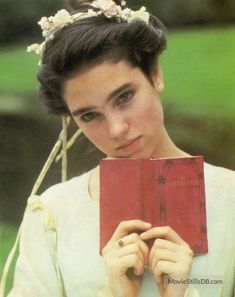 a woman holding a red book in front of her face