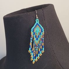 a close up of a mannequin wearing a necklace with beaded designs on it