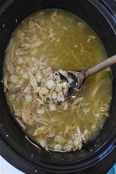 a wooden spoon in a slow cooker filled with soup