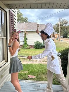 a man and woman dressed up as chefs on the front porch of a house,