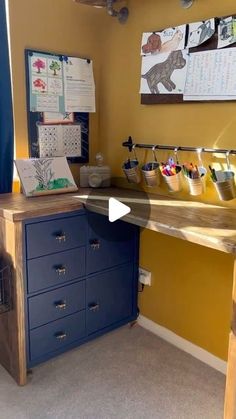 a desk with several drawers in front of it and a yellow wall behind the desk