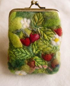 a small purse with berries and leaves on it