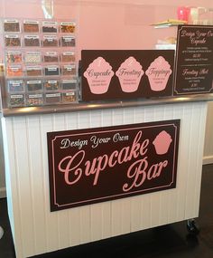 a cupcake shop counter with signs on it