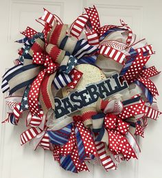 a red, white and blue wreath with the word baseball on it is hanging on a door