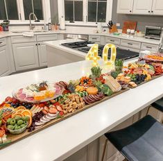 a table filled with lots of food on top of a kitchen counter next to an oven