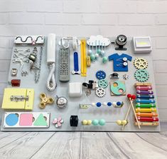 a table topped with lots of assorted items on top of a wooden floor next to a white brick wall