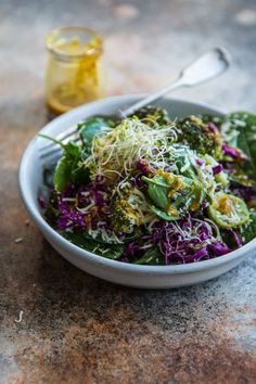 a white bowl filled with vegetables and sprouts